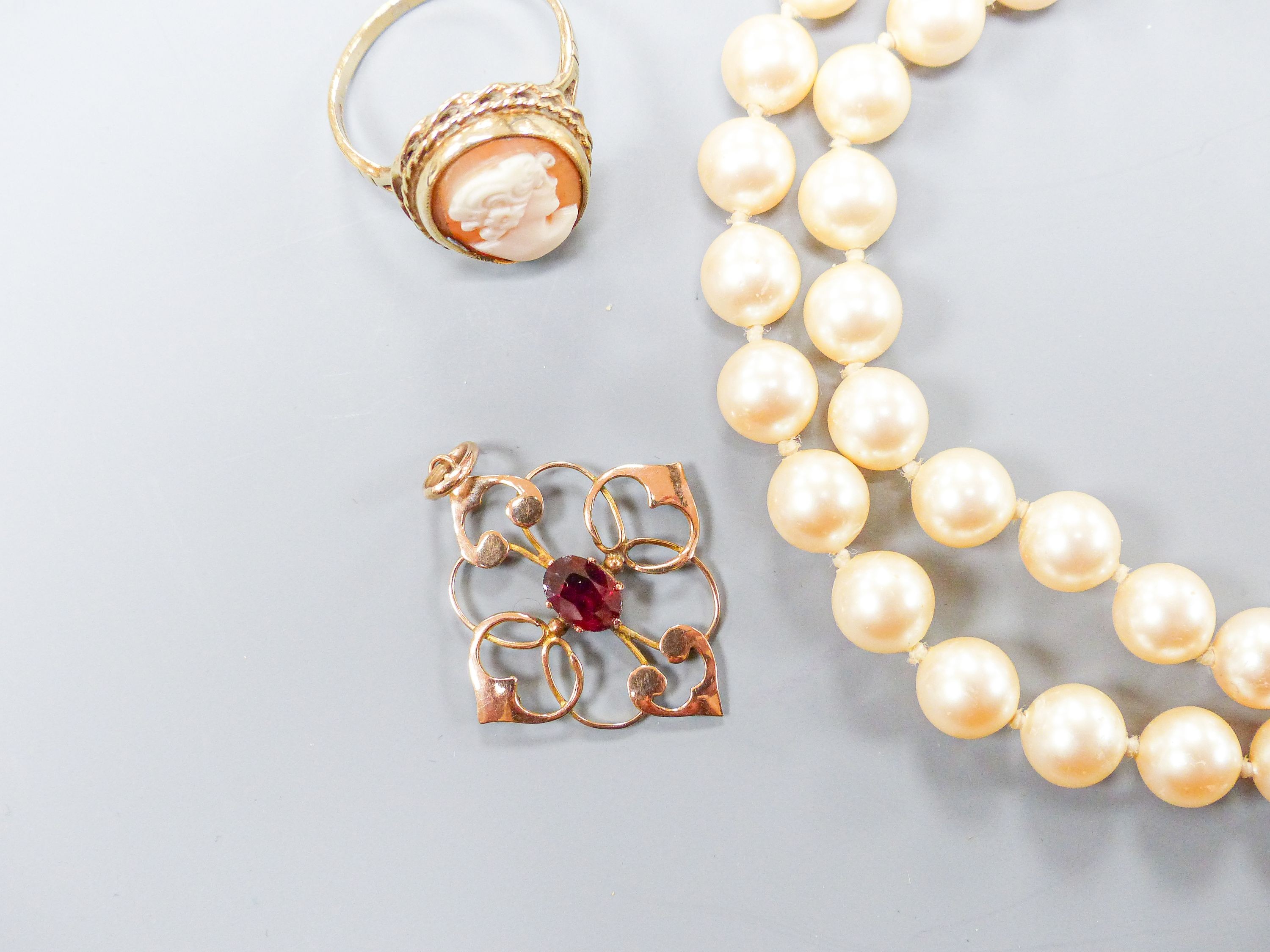 A 9ct gold and cameo shell oval ring, a 9ct and garnet set pendant and a simulated pearl necklace.